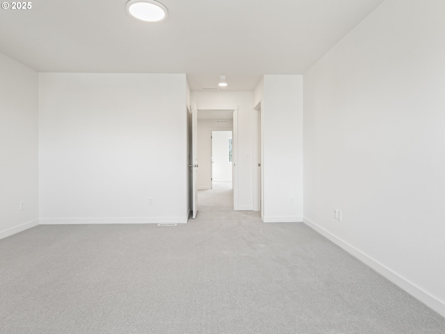 unfurnished room featuring carpet and baseboards