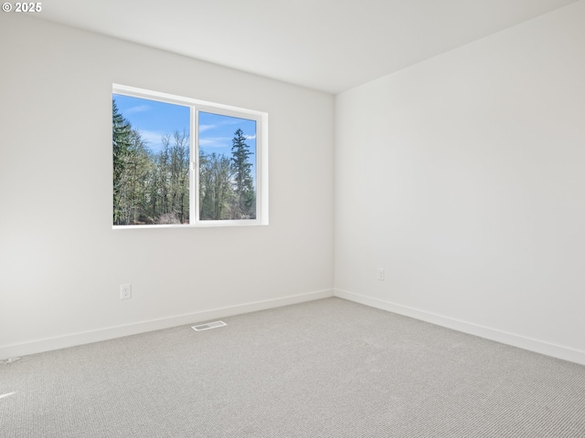 carpeted spare room with baseboards and visible vents