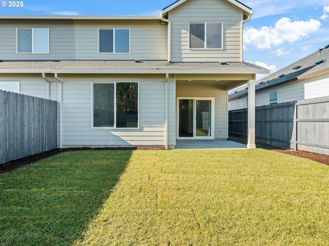 back of house with a fenced backyard, a shingled roof, a patio, and a yard