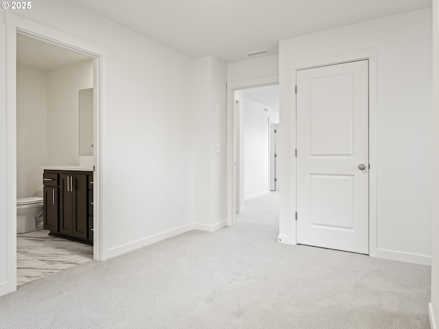 spare room featuring visible vents, baseboards, and light colored carpet