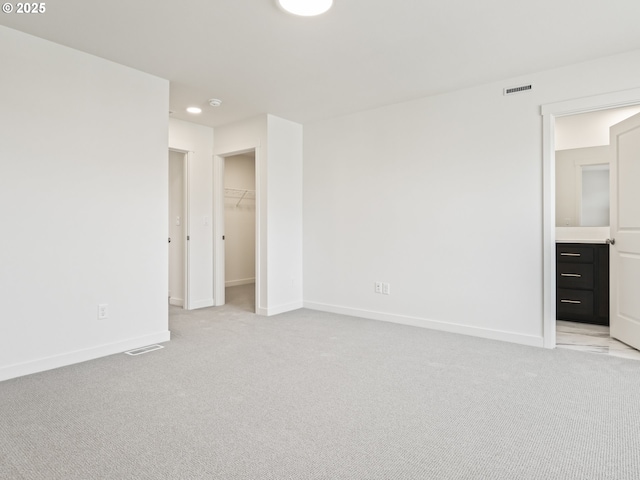 unfurnished bedroom featuring light carpet, baseboards, and visible vents