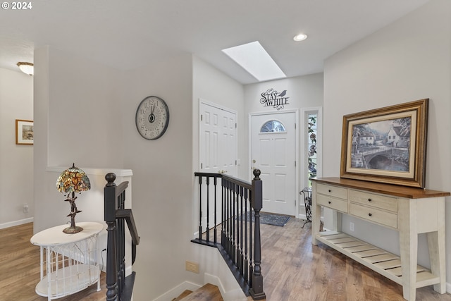 foyer entrance featuring a skylight and wood-type flooring