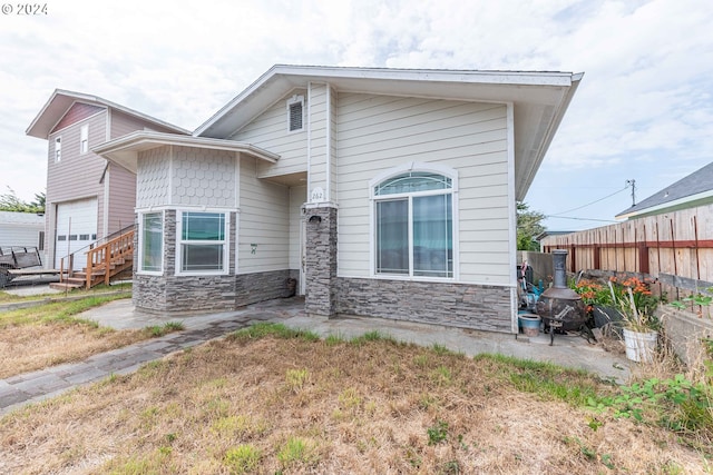 view of front of house with stone siding and fence