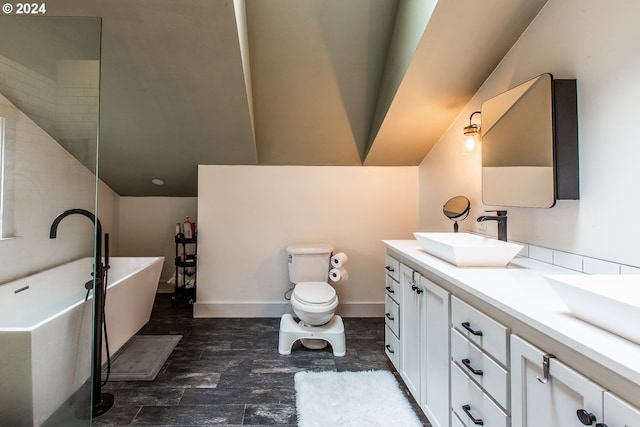 bathroom with vanity, toilet, and a washtub