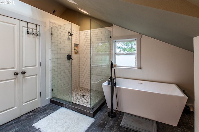 bathroom featuring independent shower and bath, hardwood / wood-style flooring, and lofted ceiling