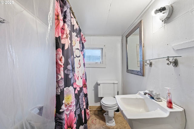 bathroom featuring a shower with shower curtain, toilet, and sink