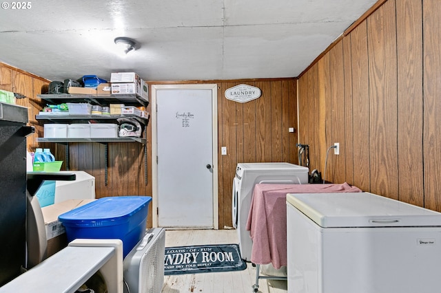 washroom featuring wooden walls and washing machine and clothes dryer