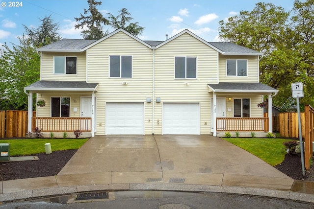 view of front of home with a front lawn, covered porch, and a garage