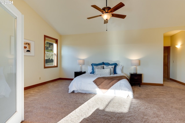 bedroom featuring ceiling fan, arched walkways, light carpet, baseboards, and vaulted ceiling