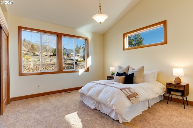 bedroom with light colored carpet, visible vents, vaulted ceiling, and baseboards