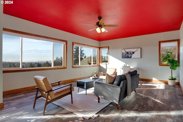 living room featuring wood finished floors, a ceiling fan, and baseboards