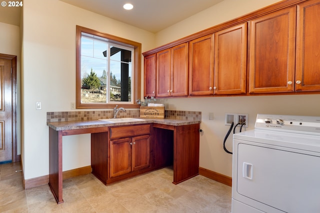 clothes washing area featuring recessed lighting, a sink, baseboards, cabinet space, and washer / clothes dryer