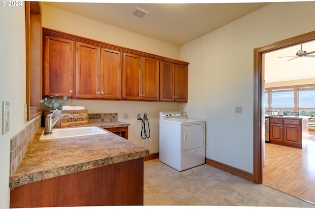 laundry room featuring washer / dryer, cabinet space, baseboards, visible vents, and a sink