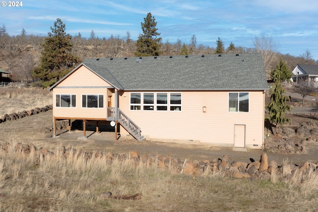 back of house featuring a shingled roof and stairway