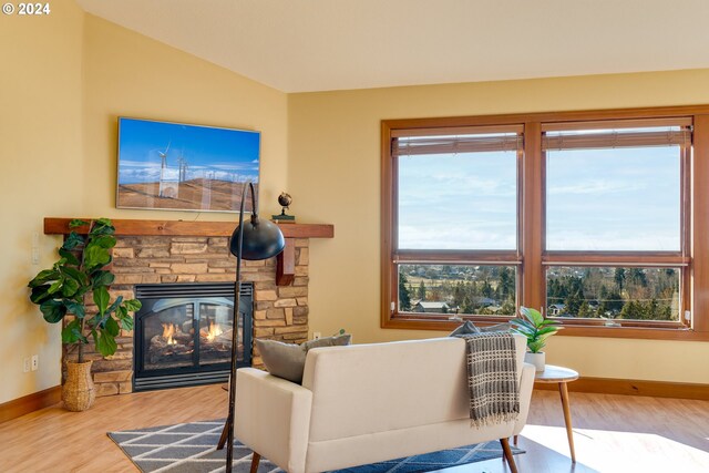 living room with hardwood / wood-style floors, a fireplace, and vaulted ceiling