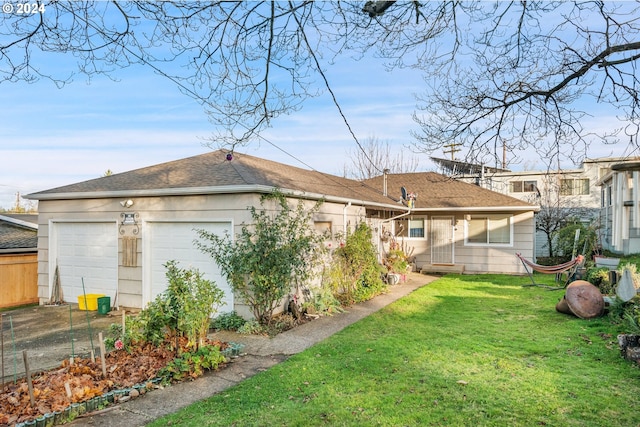 back of house featuring a yard and a garage