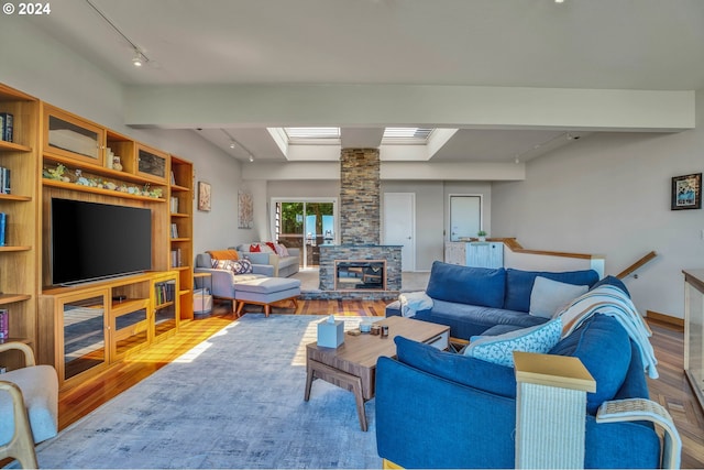 living room featuring ornate columns, a fireplace, rail lighting, and wood-type flooring