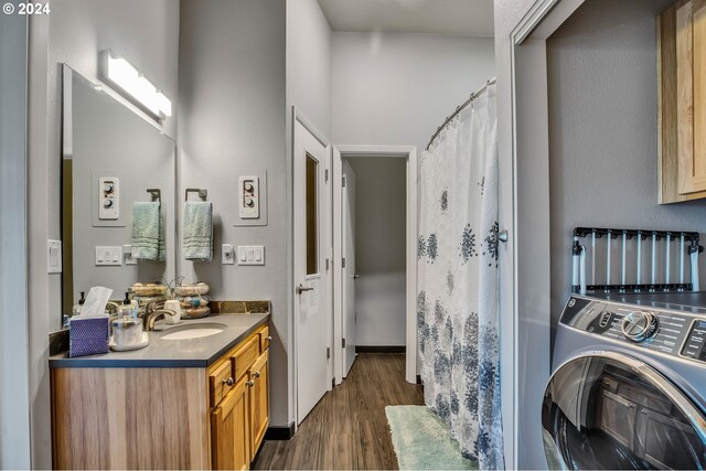 interior space featuring washer / clothes dryer, vanity, and wood-type flooring