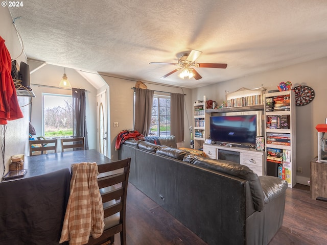 living room with a healthy amount of sunlight, dark wood-type flooring, ceiling fan, and a textured ceiling