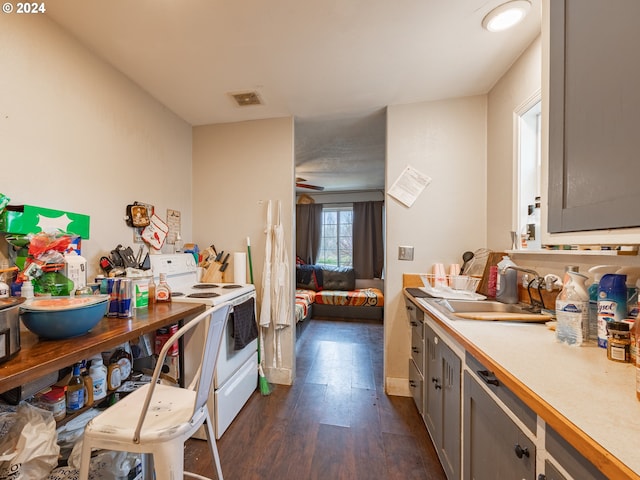 kitchen with dark wood-type flooring, white range with electric cooktop, and sink