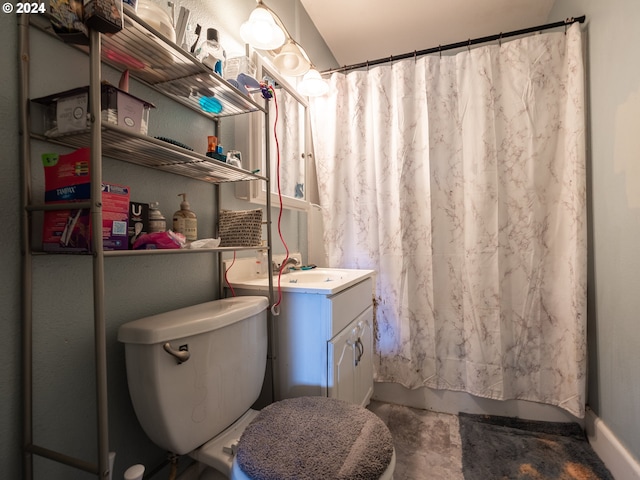 bathroom featuring concrete floors, vanity, and toilet