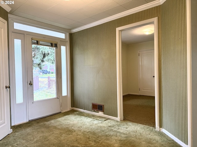 entryway with ornamental molding and light colored carpet