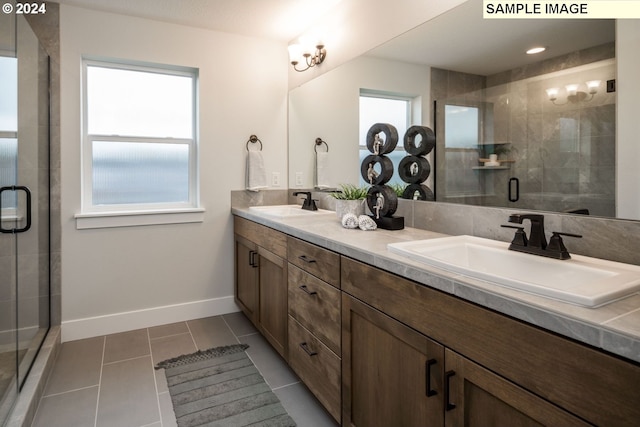 bathroom with tile patterned floors, plenty of natural light, vanity, and a shower with shower door