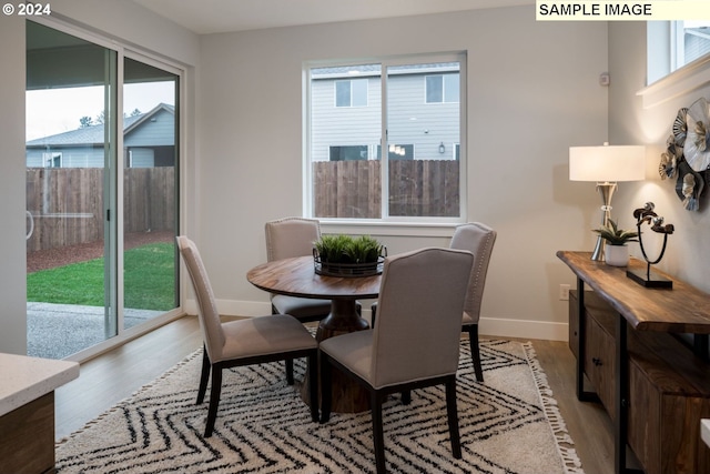 dining room featuring a healthy amount of sunlight and light hardwood / wood-style flooring