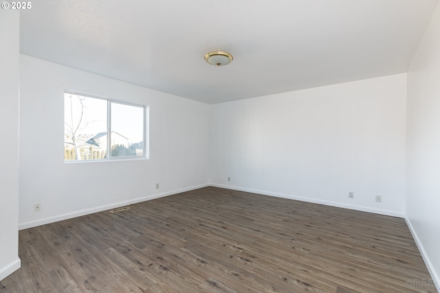 spare room featuring dark hardwood / wood-style flooring