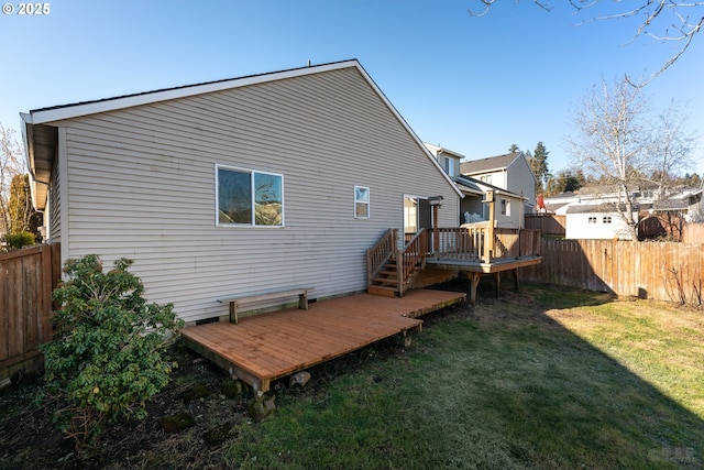 rear view of property featuring a lawn and a deck