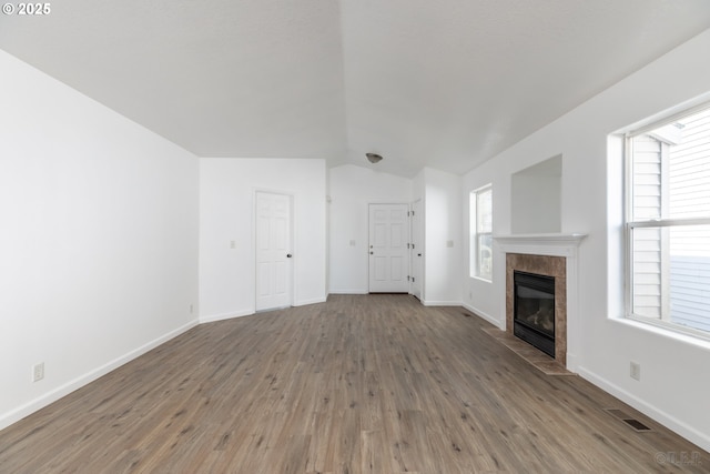 unfurnished living room featuring wood-type flooring, vaulted ceiling, and a fireplace