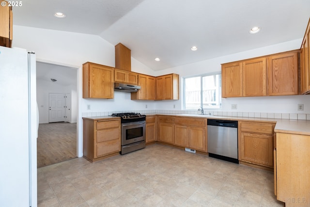 kitchen with stainless steel appliances, vaulted ceiling, and sink