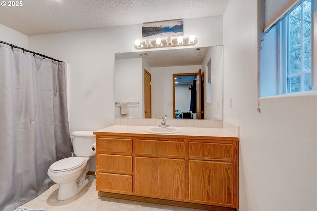 bathroom featuring curtained shower, vanity, a textured ceiling, and toilet