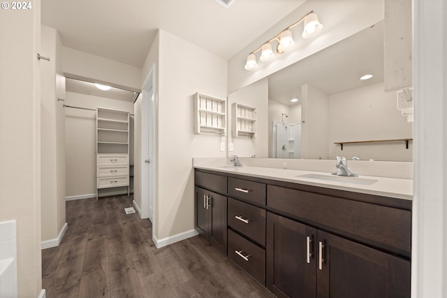 bathroom featuring walk in shower, vanity, and hardwood / wood-style floors