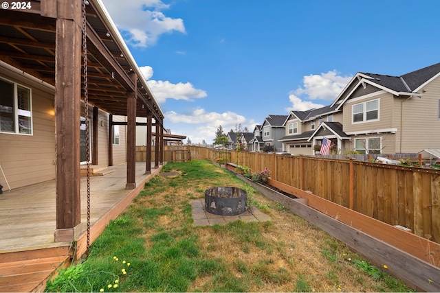 view of yard with a deck and an outdoor fire pit