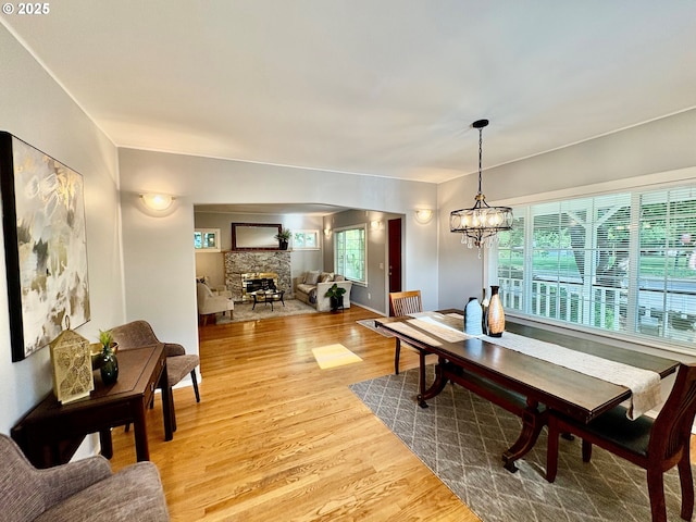 3329 SE Steele St, Portland, OR 97202 - dining area with a fireplace, wood finished floors, and a chandelier