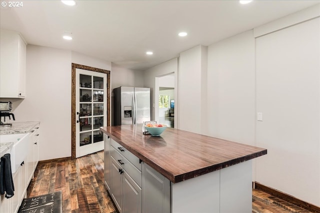 kitchen featuring wood counters, stainless steel fridge with ice dispenser, a center island, and dark hardwood / wood-style flooring