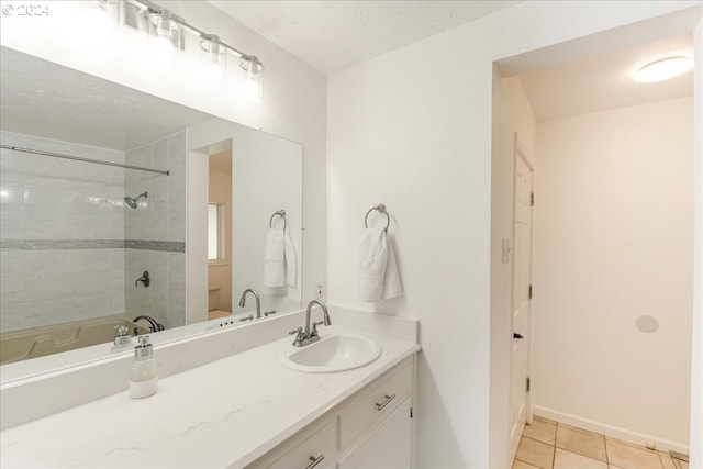 bathroom featuring tile patterned flooring, vanity, and tiled shower / bath