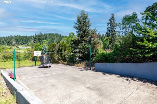 view of patio / terrace with basketball court and a trampoline