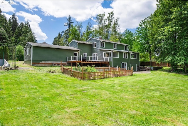 back of property with a deck and a lawn