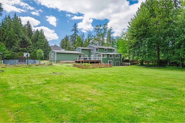 rear view of property featuring a yard and a wooden deck