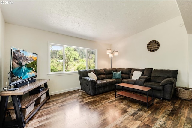 living room with a textured ceiling and dark wood-type flooring