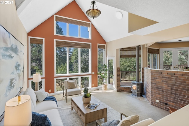 sunroom / solarium featuring a wood stove and lofted ceiling