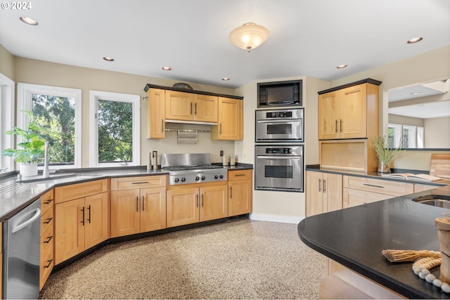 kitchen with appliances with stainless steel finishes, sink, and light brown cabinets