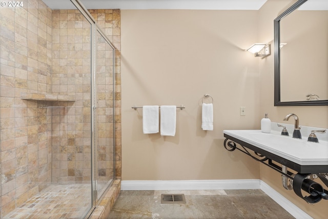 bathroom with a shower with door and sink