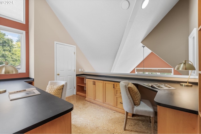 home office with built in desk and vaulted ceiling