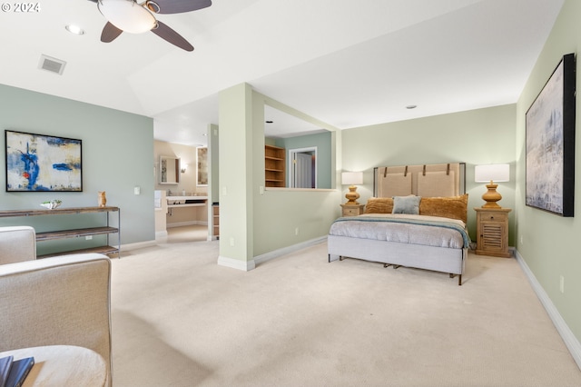 bedroom with ensuite bath, light carpet, and ceiling fan