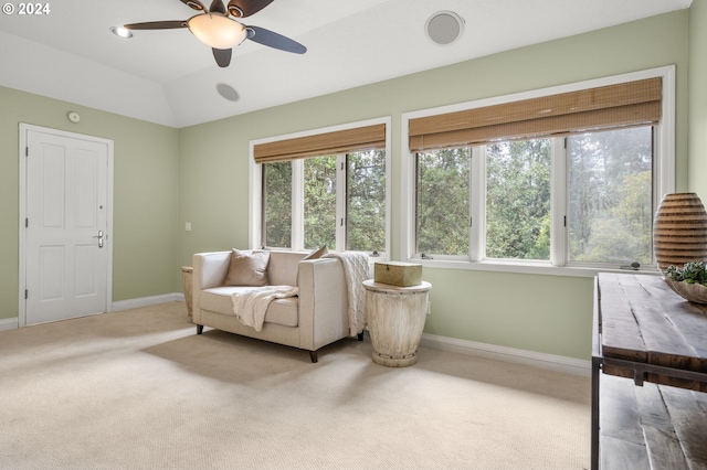 living area with light colored carpet, vaulted ceiling, and ceiling fan