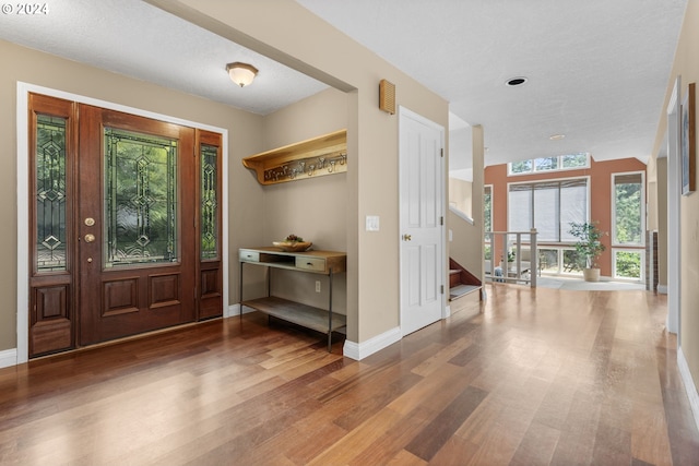 entrance foyer with a textured ceiling, hardwood / wood-style flooring, and a healthy amount of sunlight