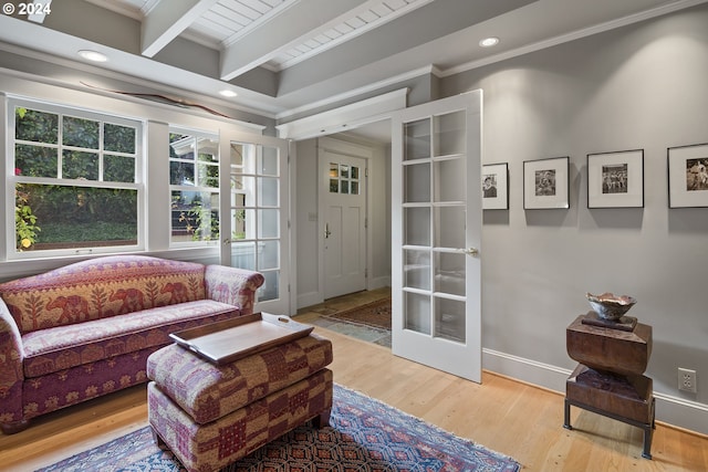 living area featuring beam ceiling, light wood-type flooring, french doors, and crown molding